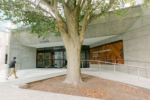 Un árbol frente a un edificio con un letrero que dice 'Walter H. Gage Residence'.