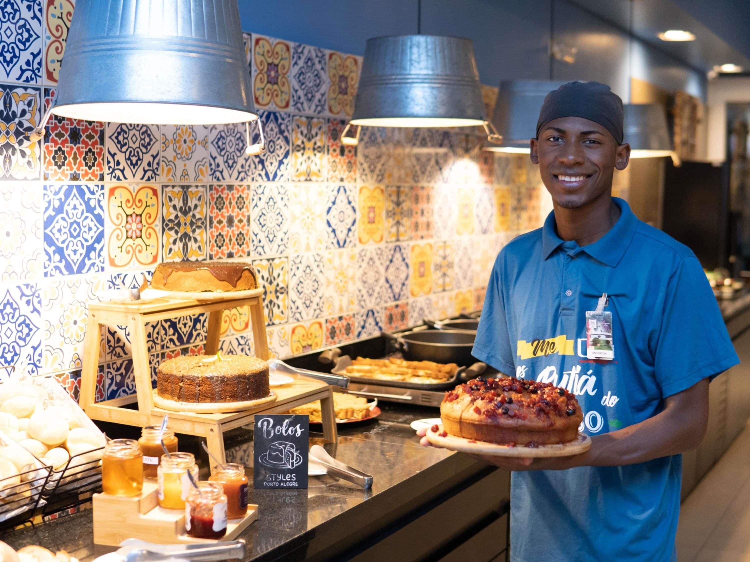 Balcão de pastelaria com diversos produtos de panificação e um letreiro indicando 'Bolos Styles Porto Alegre'.