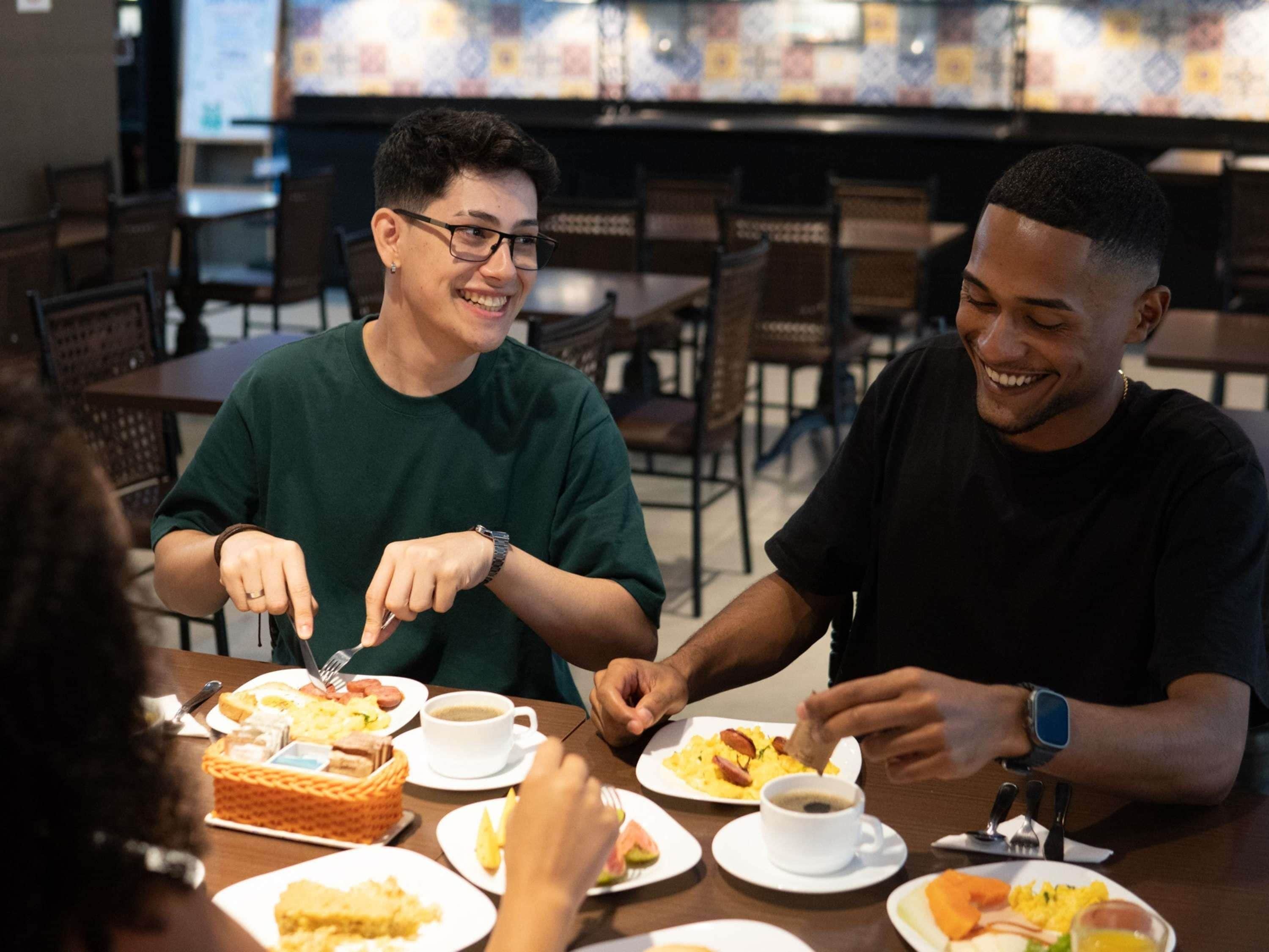 A group of people dining at a restaurant with a variety of dishes on the table.