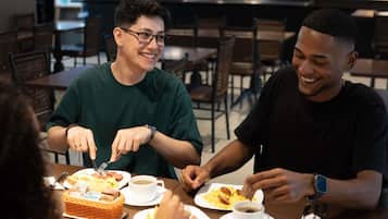 A group of people dining at a restaurant with a variety of dishes on the table.