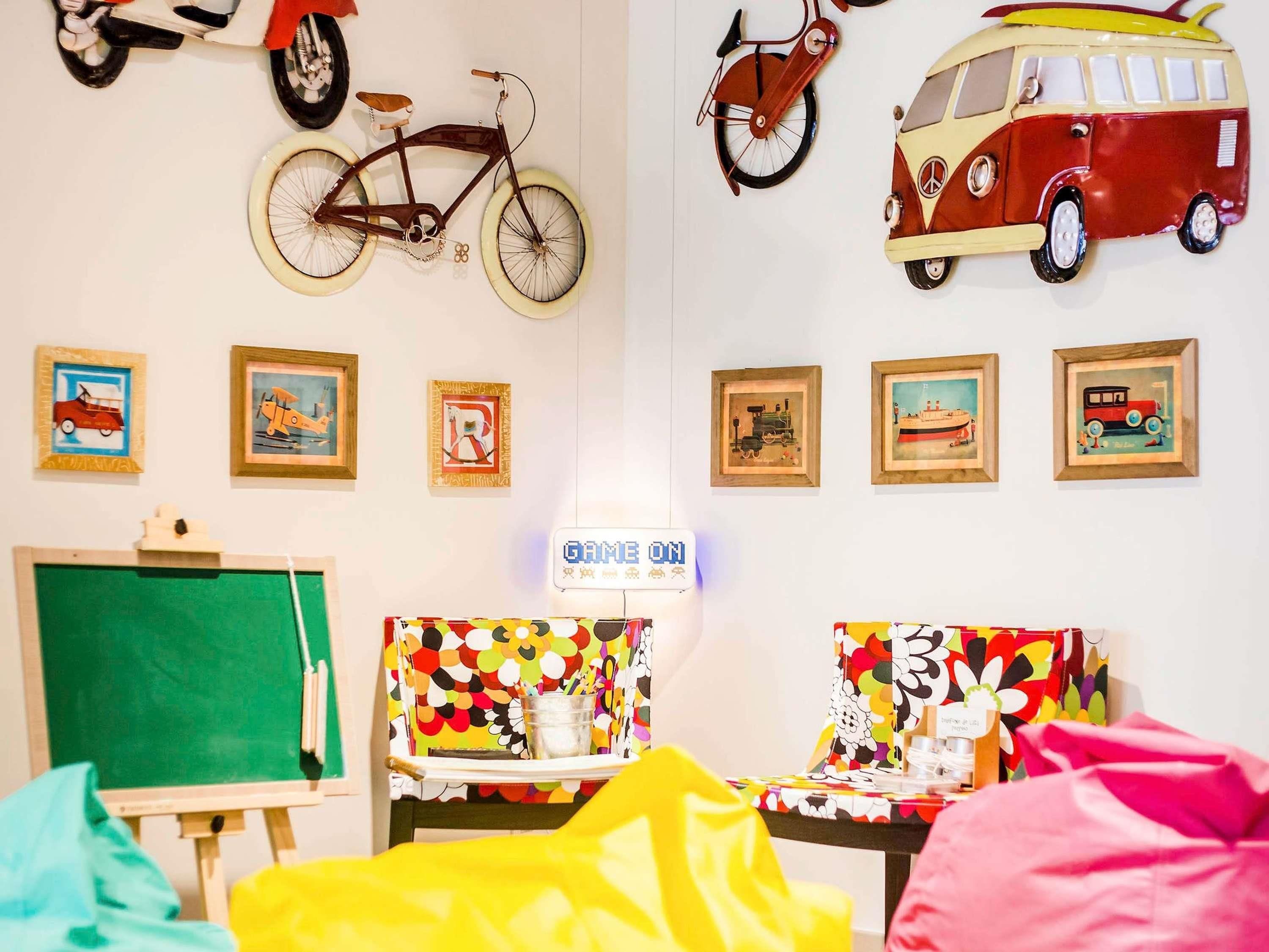 A room with a bicycle, a van, and various framed pictures on the wall.