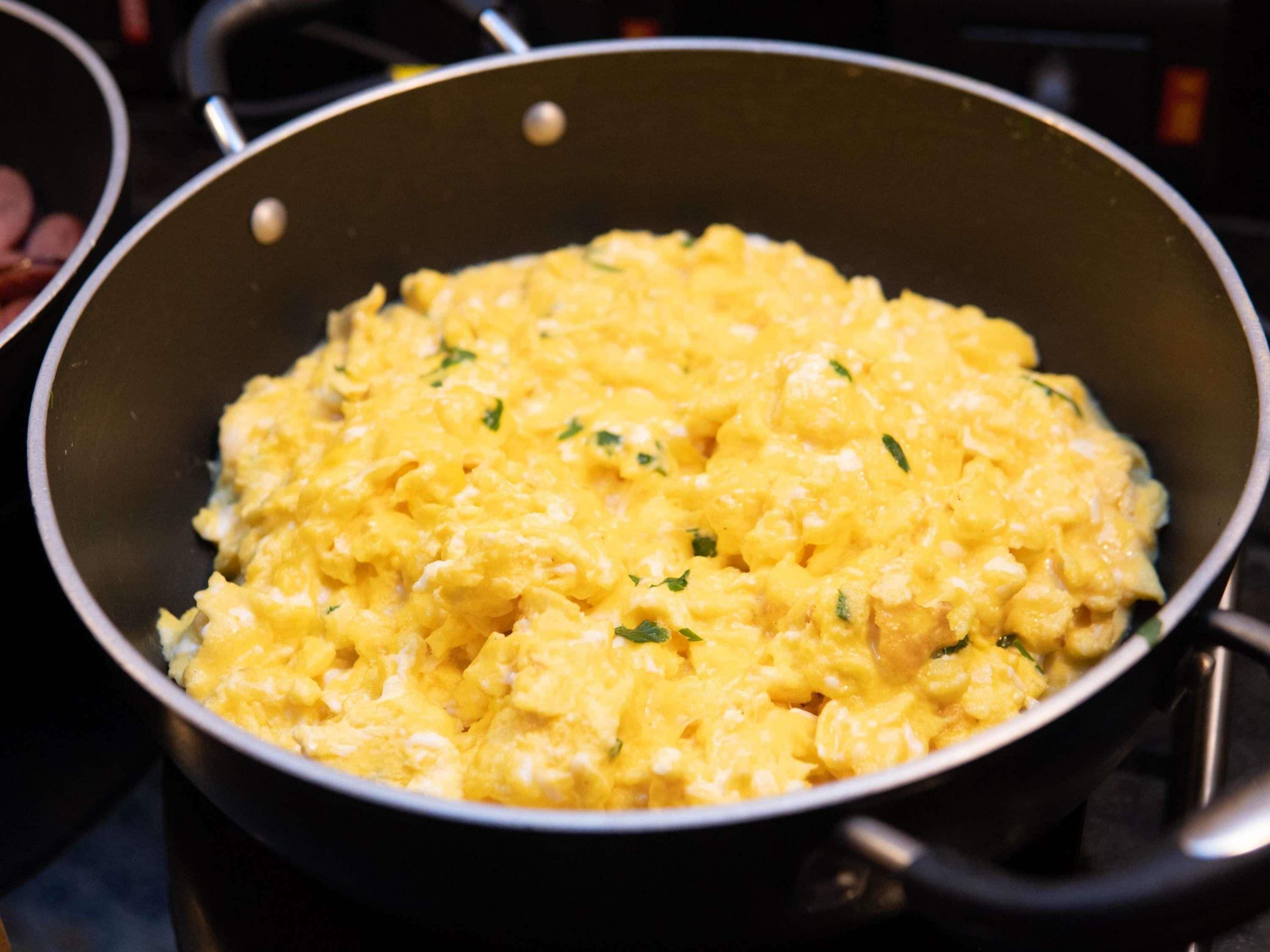 A close-up of scrambled eggs in a pan.