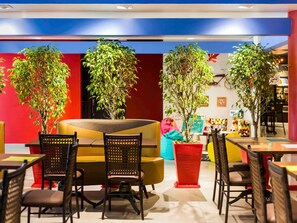 A modern dining area with round tables, black chairs, and potted plants. - ibis Styles Porto Alegre Centro (Porto Alegre)
