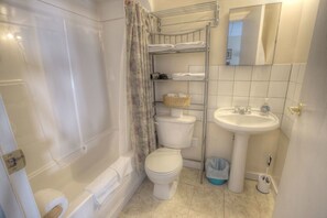 Un baño con bañera, inodoro y lavamanos.
