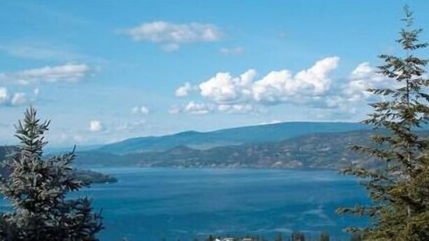 A coastal landscape with mountains in the background and a clear sky. - A View of the Lake Bed & Breakfast (West Kelowna)