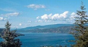 A coastal landscape with mountains in the background and a clear sky.