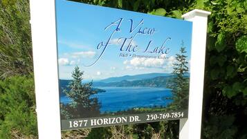 Un panneau indiquant un point de vue panoramique sur un lac et des montagnes, intitulé « Vue sur le lac », et comportant les coordonnées d’unBed and Breakfast ainsi que d’une cuisine de démonstration.