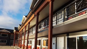 Un bâtiment à deux étages doté d’un espace extérieur couvert avec des sièges et dont le numéro de la pièce, le 29, est clairement visible.