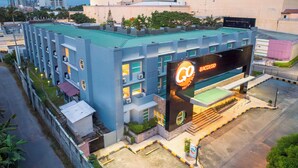A modern hotel with a prominent sign, multiple floors, and a parking area. - Go Hotels Plus Bacolod Newly Renovated (Bacolod)