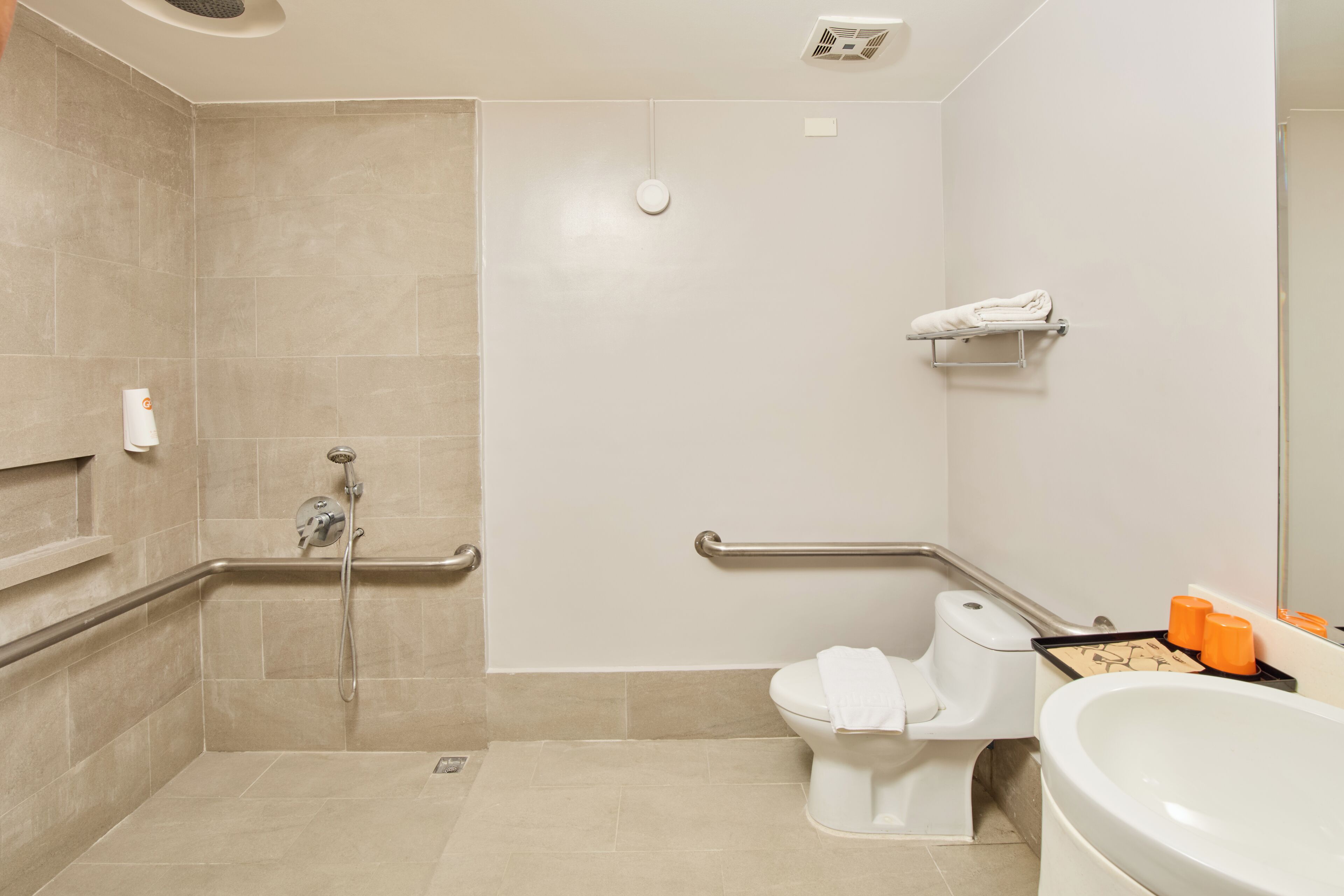 A bathroom with a shower, toilet, and sink.