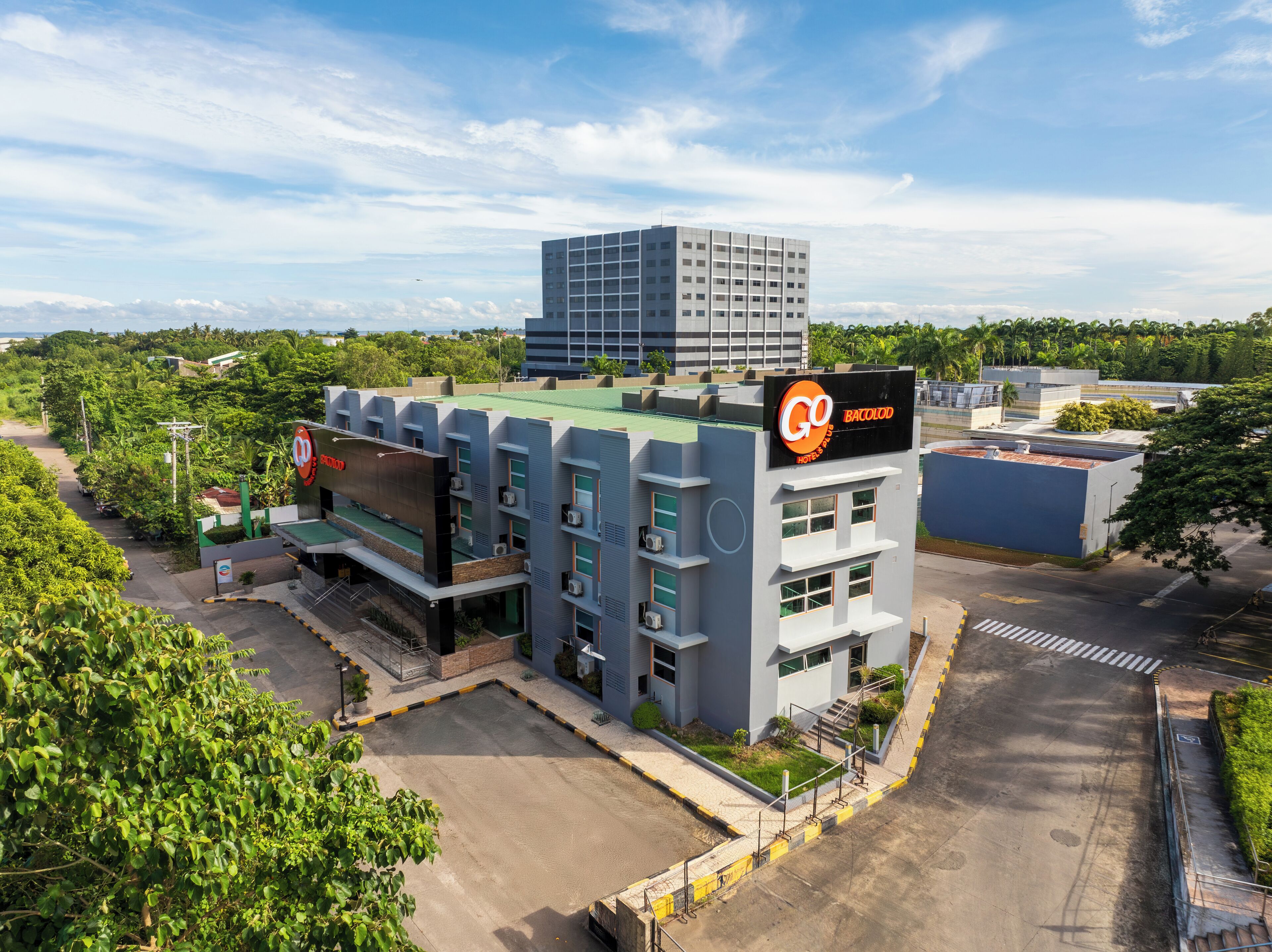 A hotel with a modern design, featuring a prominent sign for 'Go Bacolod Hotel & Suites'.