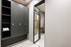 A hallway with a wardrobe, a glass door, and a wooden door. - SR Suites Pangyo (Seongnam)