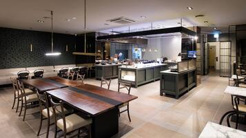 A modern kitchen with a central island, dark brick walls, and contemporary lighting fixtures.