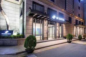 The exterior of SR Hotel Suites with a modern entrance, large glass doors, and potted plants. - SR Suites Pangyo (Seongnam)