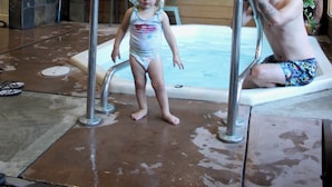 Ein Holzinnenraum mit Schwimmbad, Deckenventilator und einer Bärenstatue.