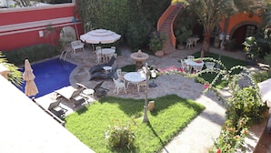 A courtyard with a swimming pool, outdoor seating, and lush greenery. - Collection O Casa Bella Hotel Boutique, Cabo San Lucas (Cabo San Lucas)
