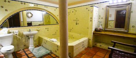 Ein Badezimmer mit Toilette, Waschbecken, Badewanne und Spiegel.