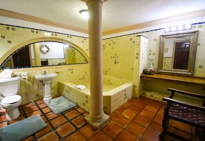 Een badkamer met toilet, wastafel, bad en een spiegel.