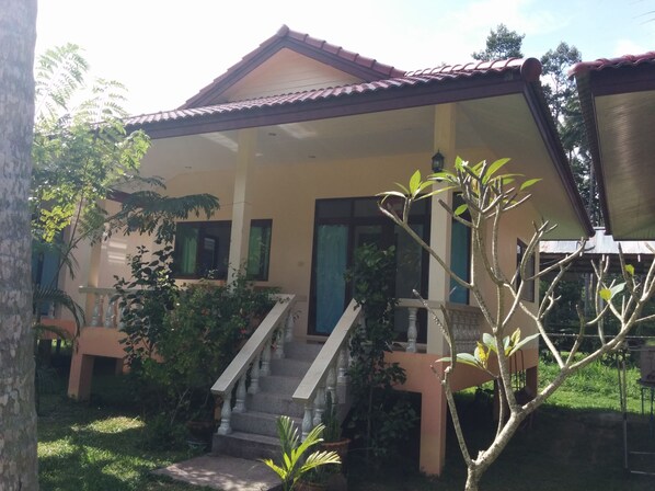 A two-story house with a covered porch, a staircase, and a small garden area. - Paradise Garden Resort (Ko Pha-ngan)