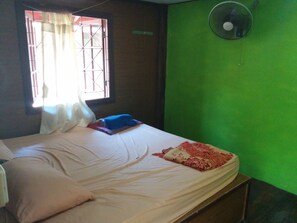 A room with a bed, a window with curtains, a fan, and a green wall. - Paradise Garden Resort (Ko Pha-ngan)