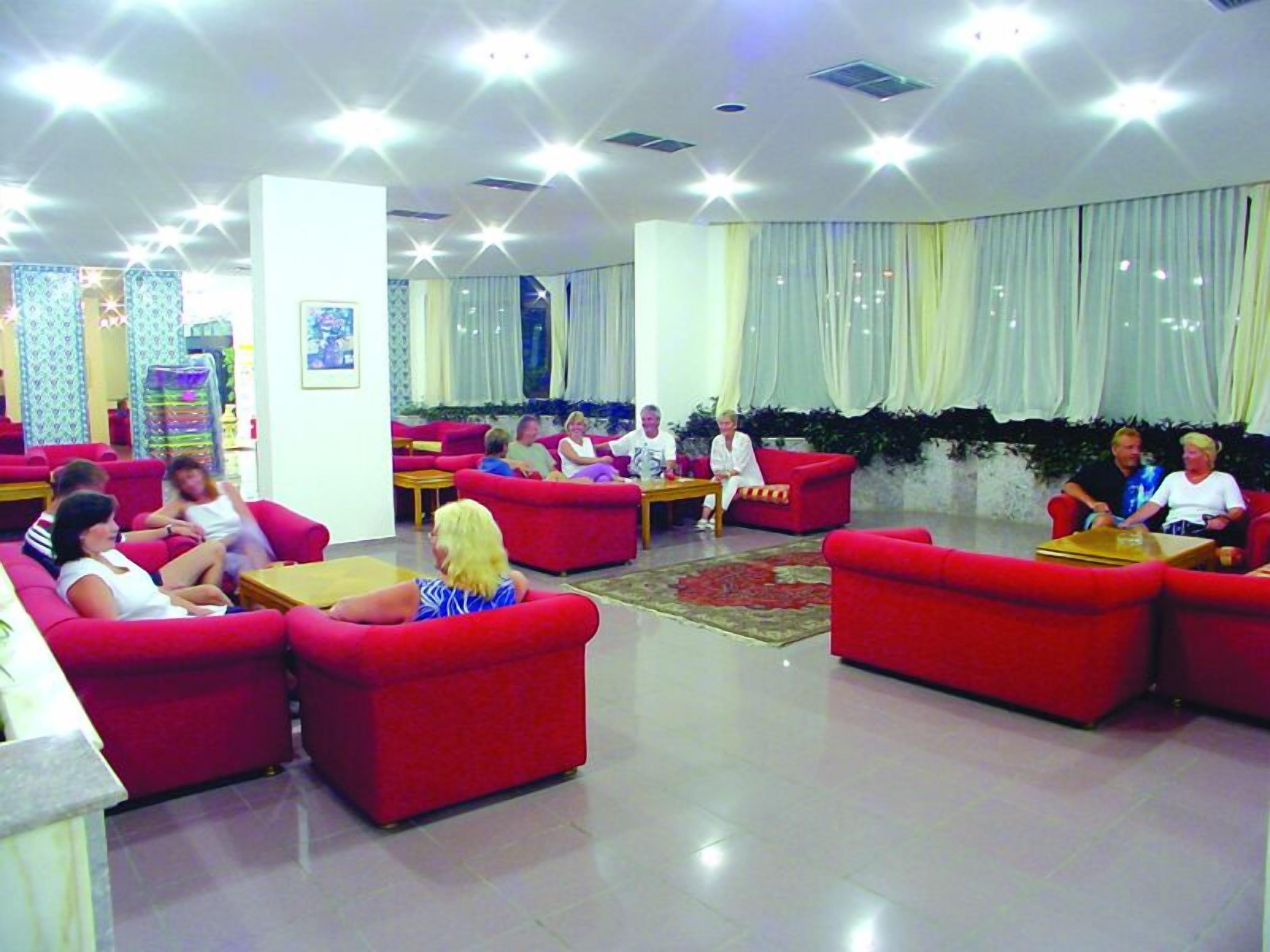 A spacious lobby with red sofas and a tiled floor.