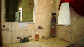 A bathroom with a sink, mirror, and a decorative statue.