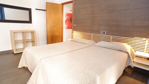 Une chambre à coucher avec un grand lit, une tête de lit en bois, une table de chevet et une armoire.