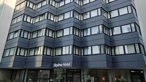Un moderno edificio de hotel con fachada en zigzag y varios pisos.