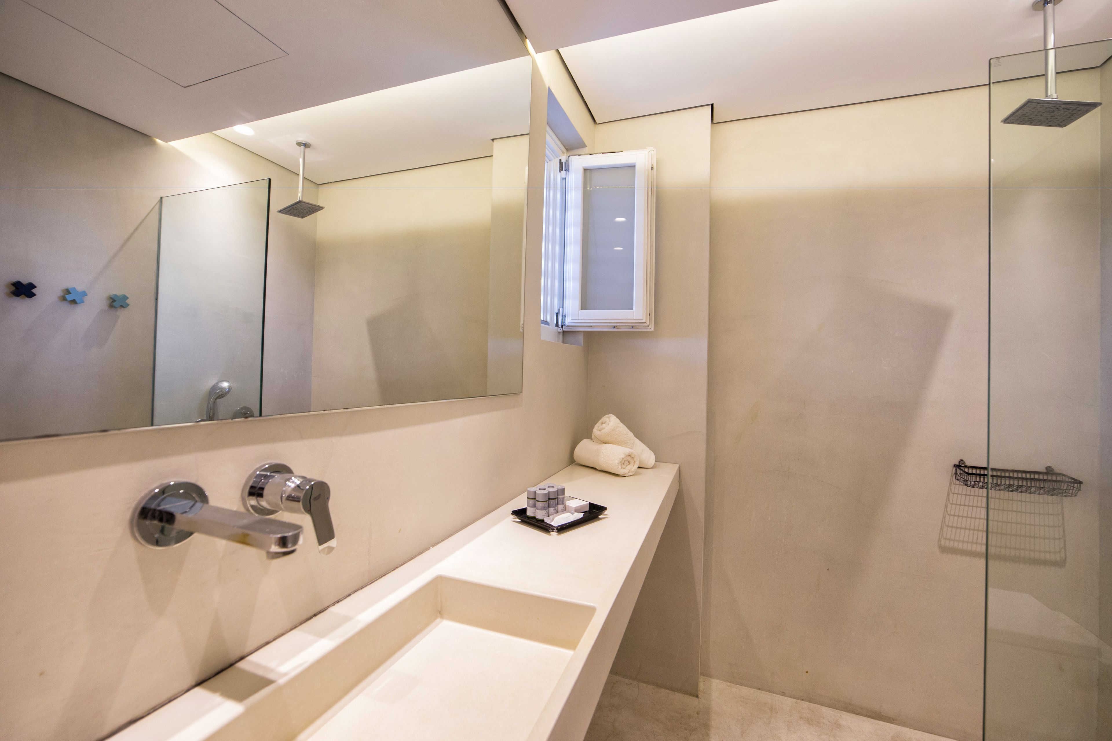 Une salle de bain moderne avec un grand miroir, une baignoire, une douche et un porte-serviettes.
