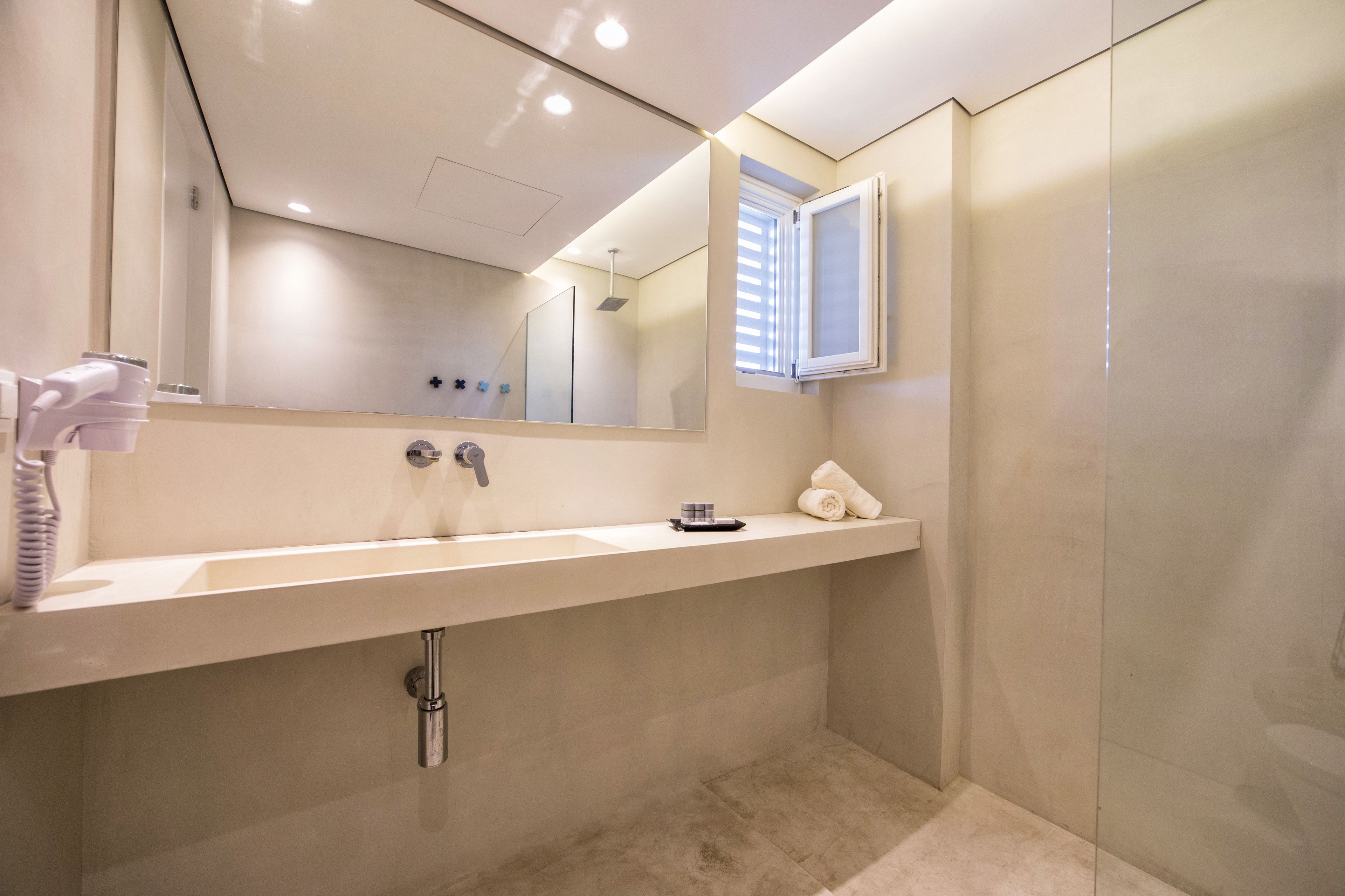 Een moderne badkamer met een grote spiegel, een wastafel en een douche.