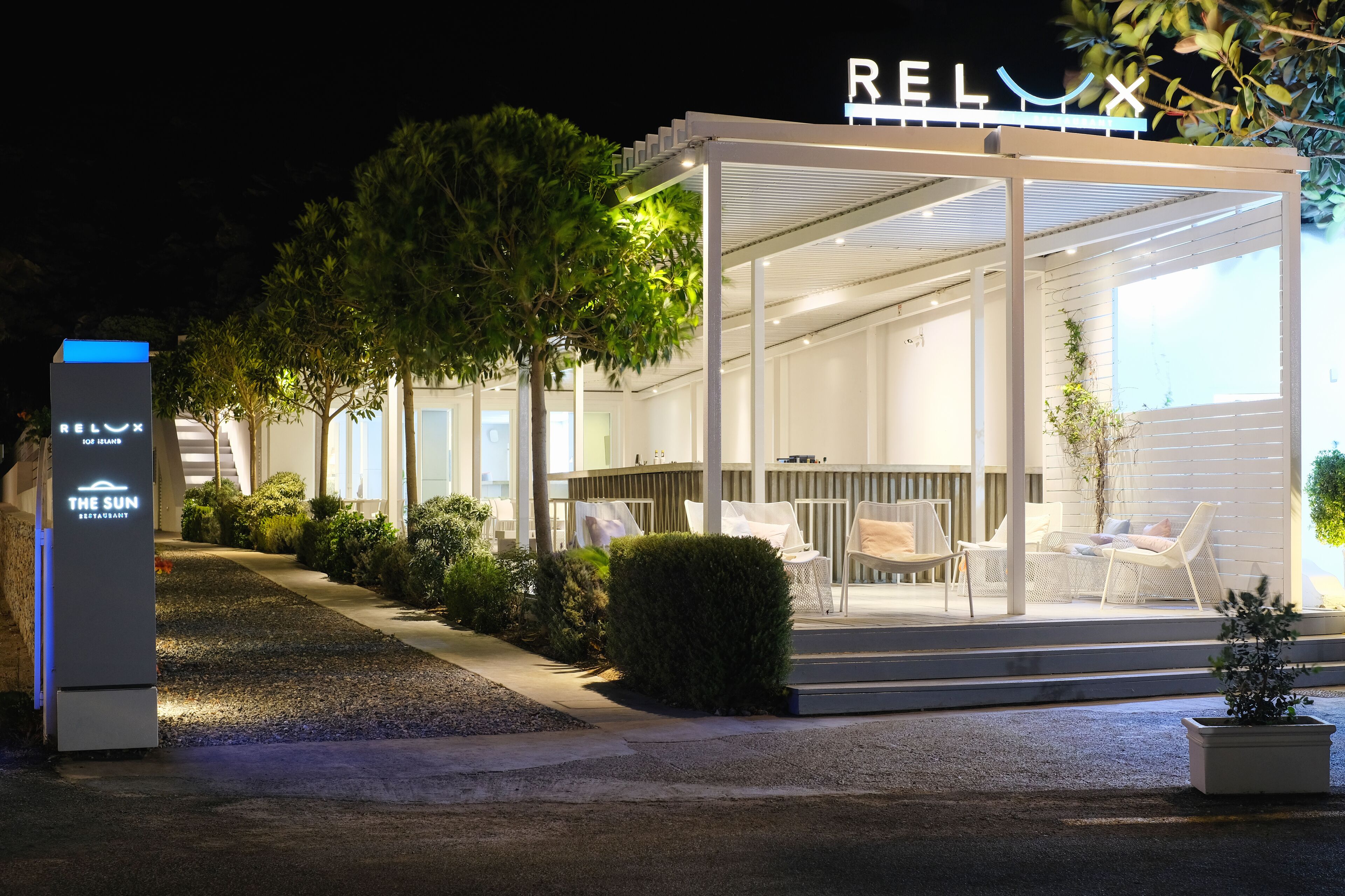 Een modern, goed verlicht buitenzitgedeelte met een goed zicht op de naam van het restaurant, 'RELAX'.