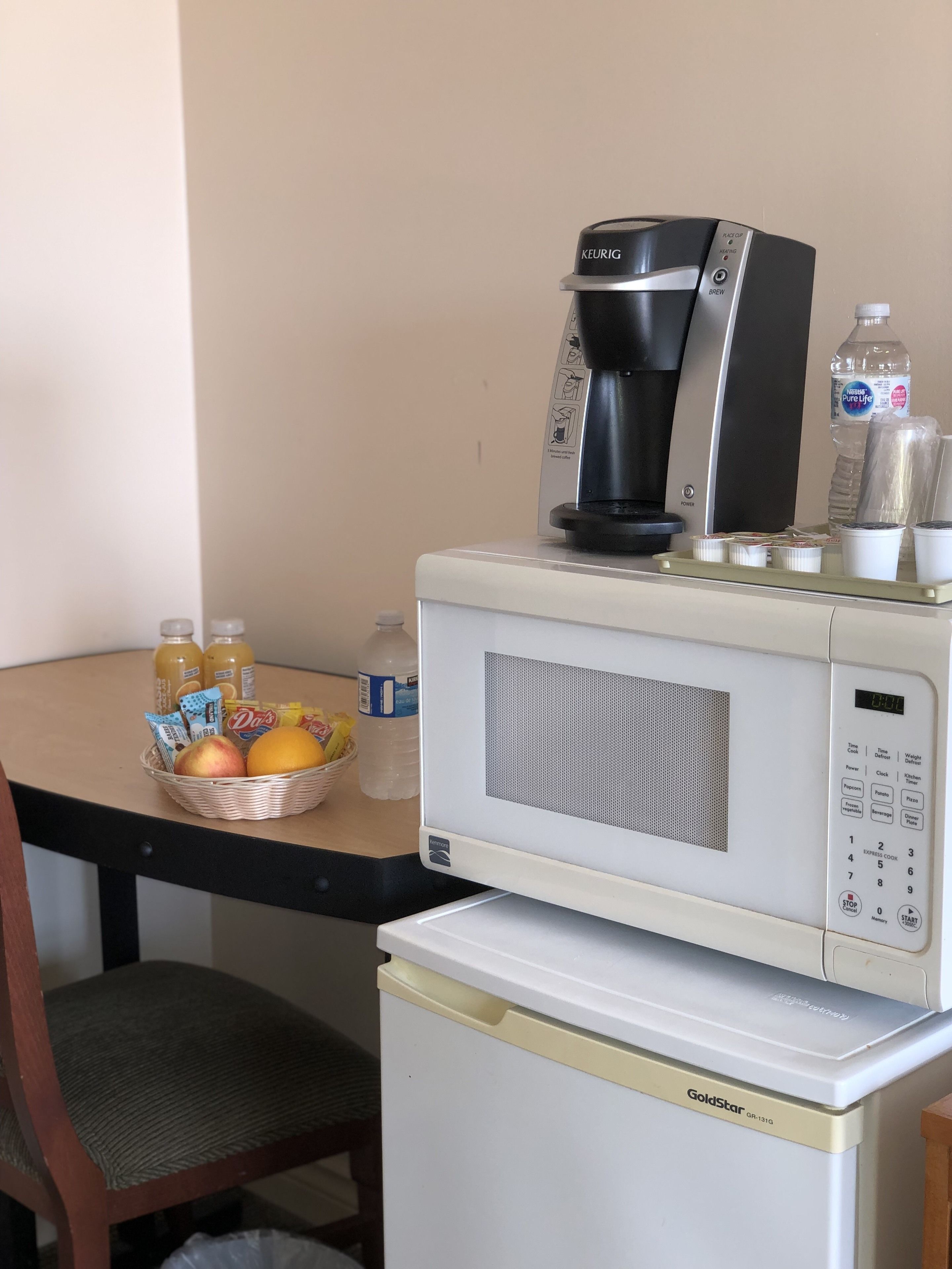 A compact kitchenette with a coffee maker, microwave, and refrigerator.