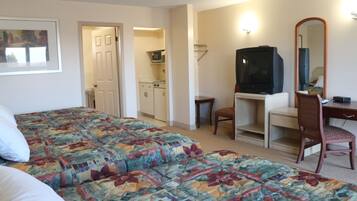 Habitació d'hotel amb dos llits, un escriptori amb cadira, televisió i microones a la cuineta.