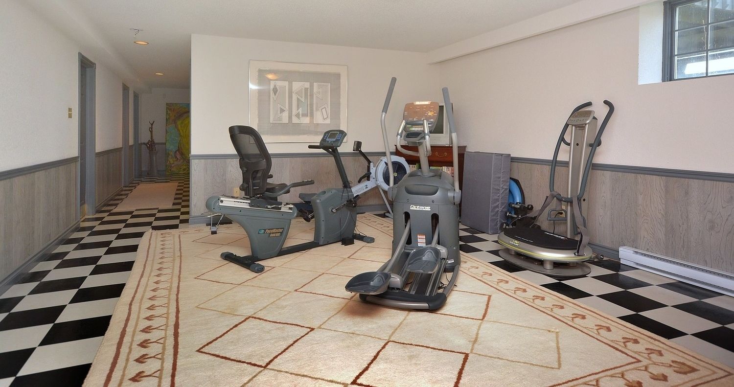 A fitness room with treadmills, elliptical machines, and a stationary bike.