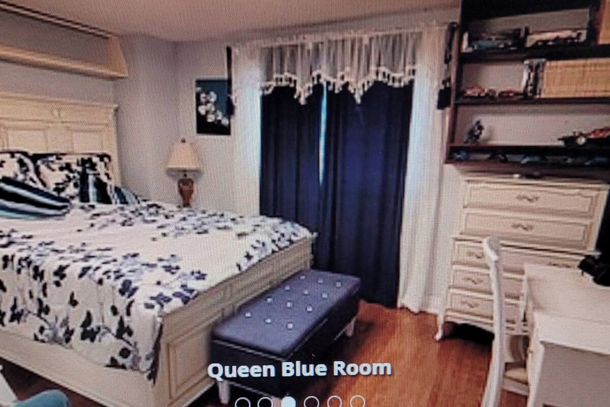 Quarto com cama, mesa de cabeceira, cômoda e escrivaninha.
