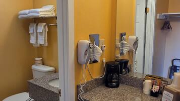 A bathroom with a toilet, sink, and mirror.