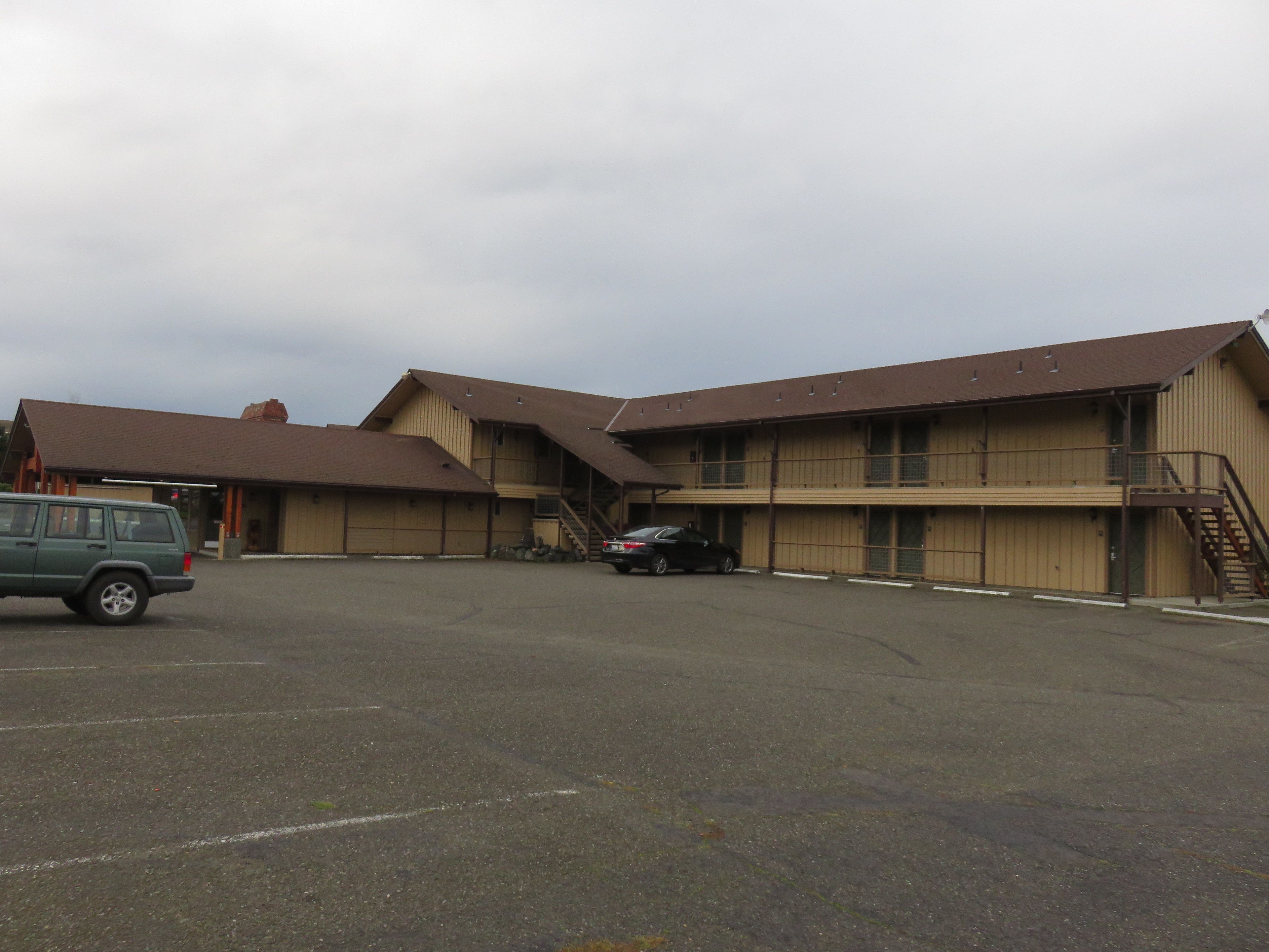 A two-story building with a parking lot in front.