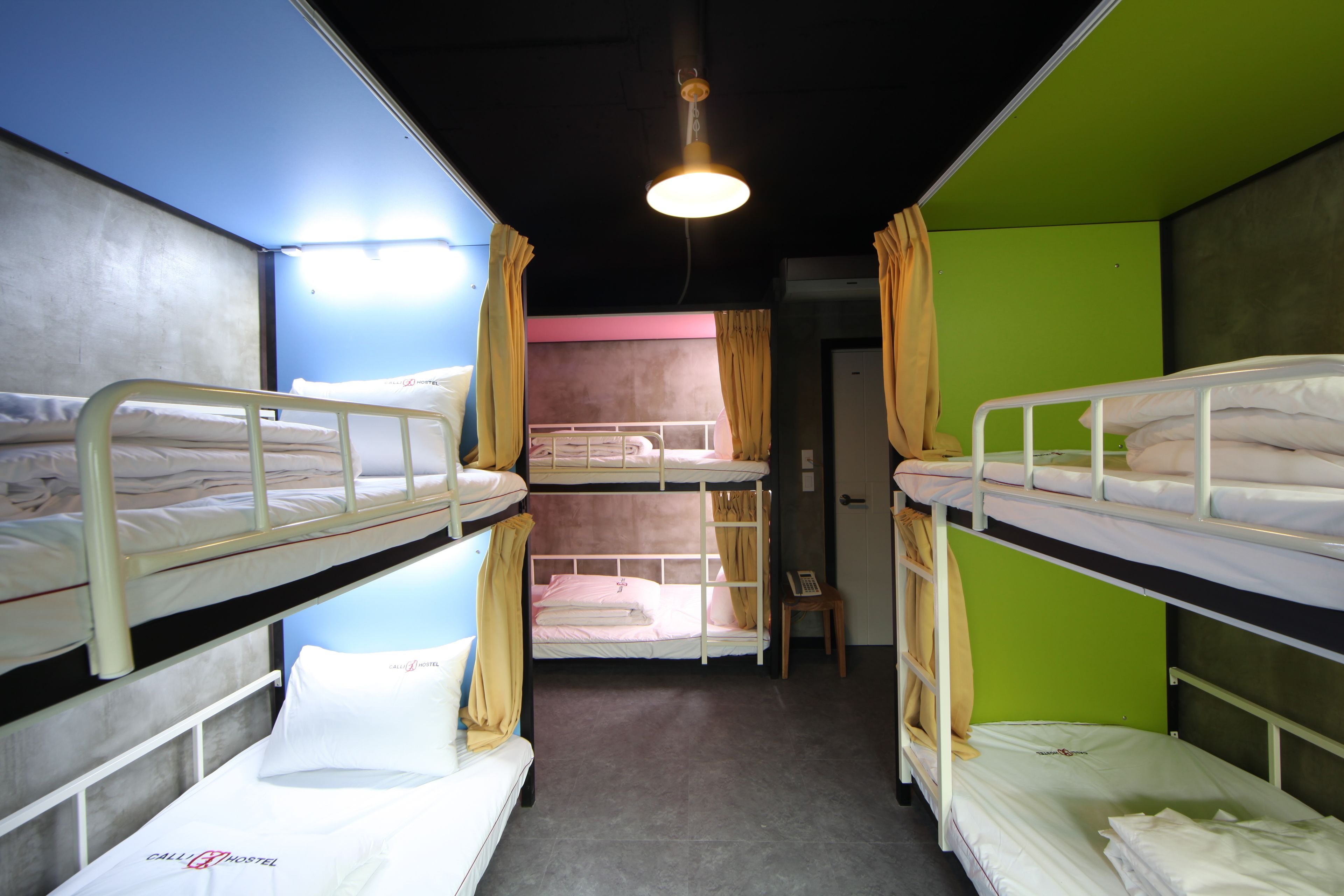 A bunk room with two beds, a small table, and a door.