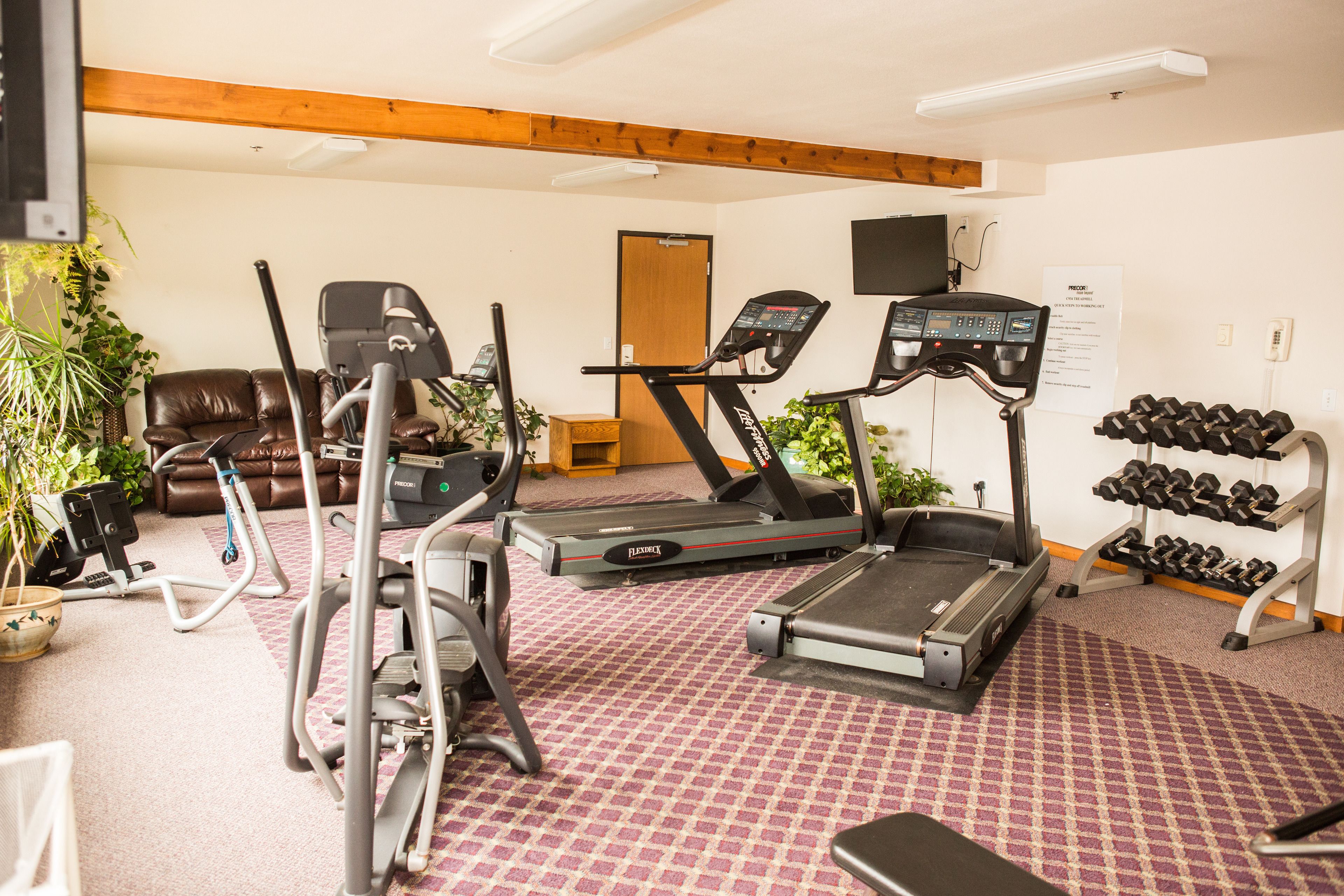 Una palestra con tapis roulant, ellittiche e un porta pesi.