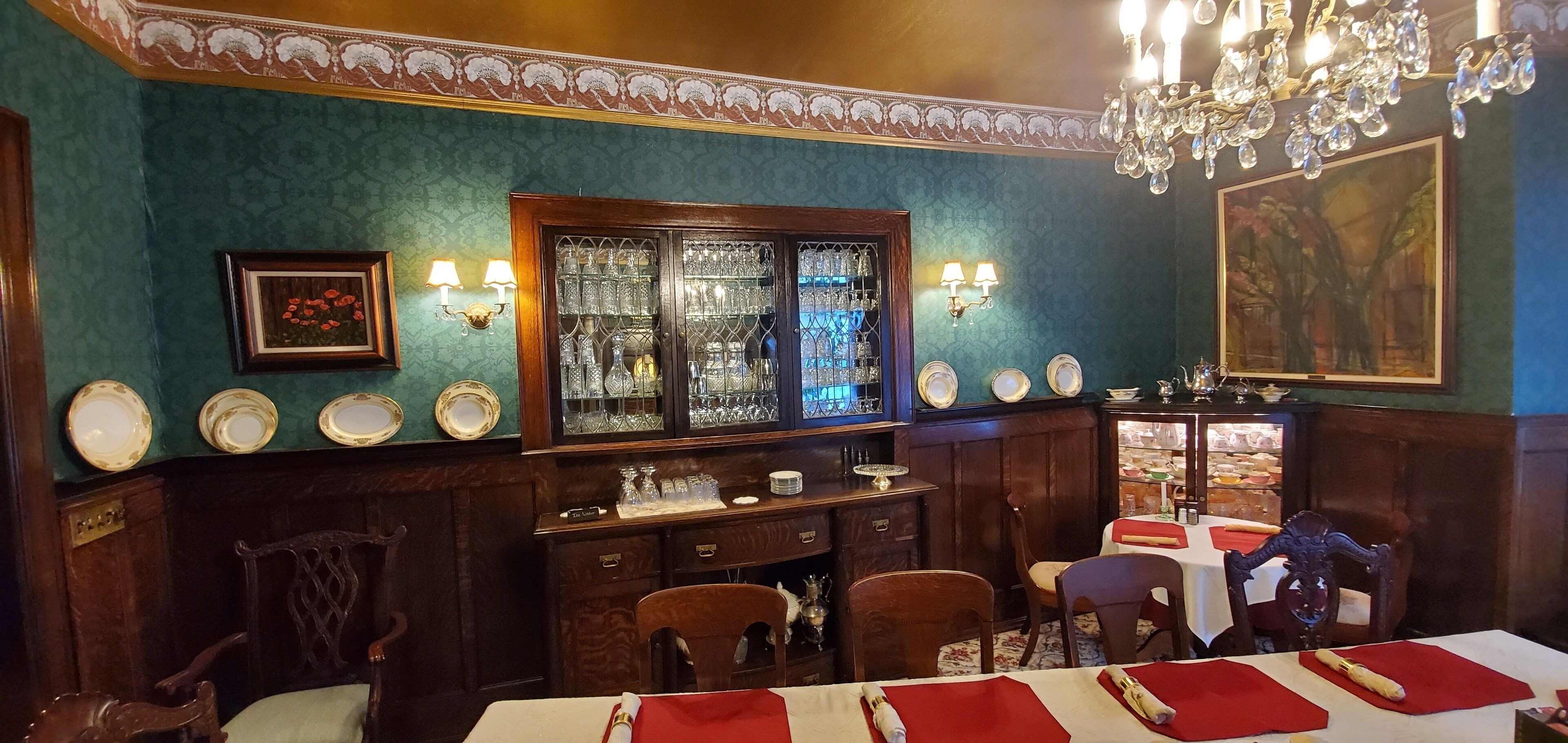 A dining area with wooden furniture, a glass display case, and wall-mounted light fixtures.