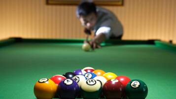 A pool table with numbered balls and a person playing.