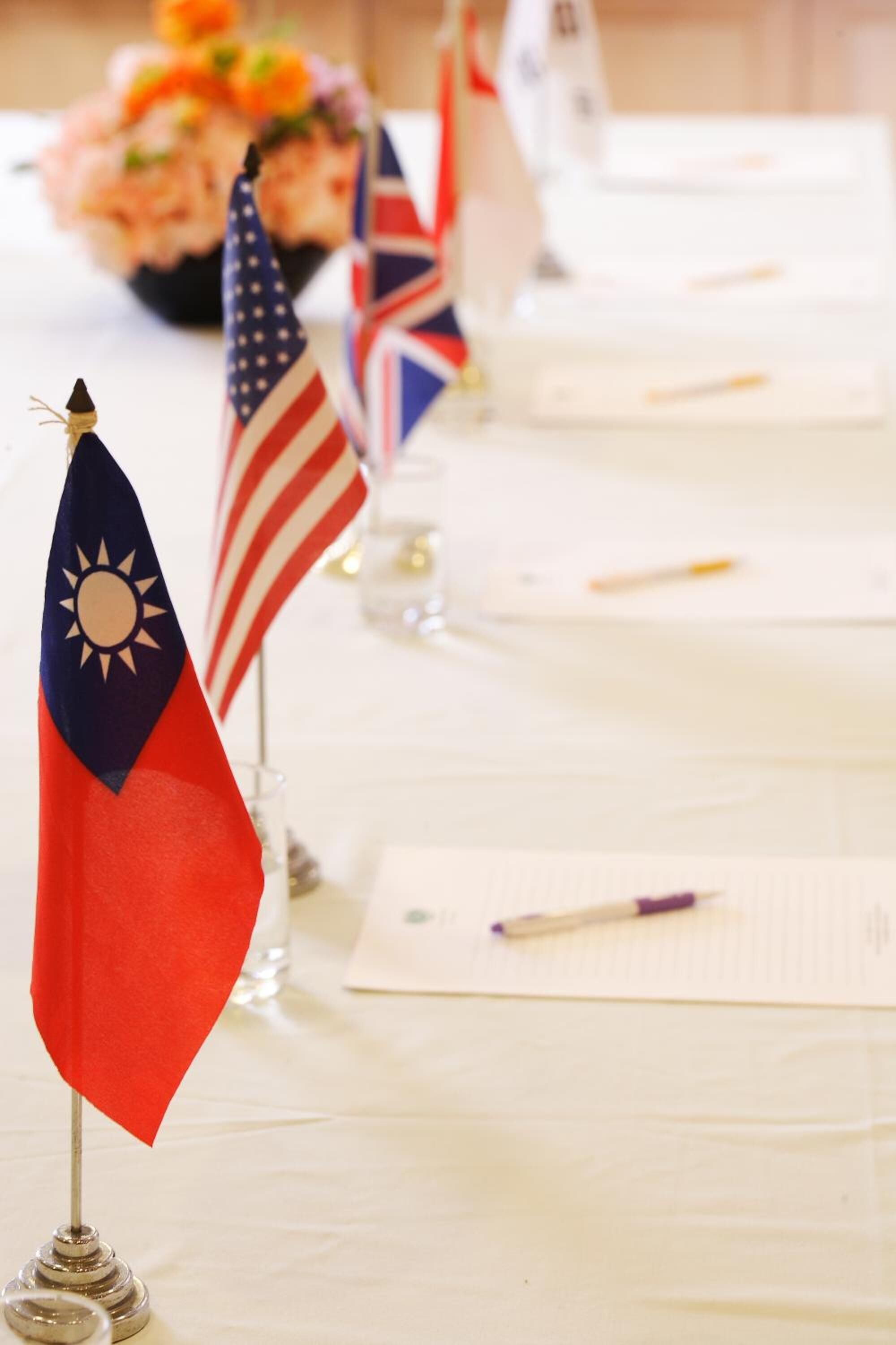 A table with flags, documents, and a pen.