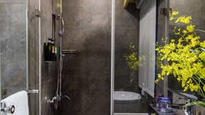 A modern bathroom with a glass-enclosed shower, a white sink, and a mirror reflecting a yellow flower. - Beauty Hotels Taipei - Hotel Bstay (Taipei)