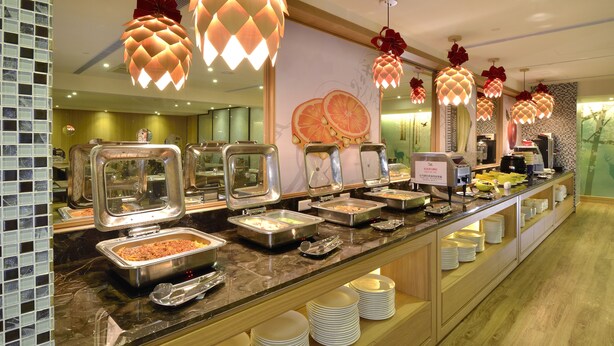 Un bufé con distintas estaciones de comida e iluminación decorativa.