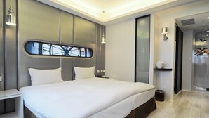 Un dormitorio moderno con una cama grande, una mesita de noche y un velador.