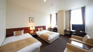 Une chambre d’hôtel avec deux lits, une télévision, un bureau et une chaise.