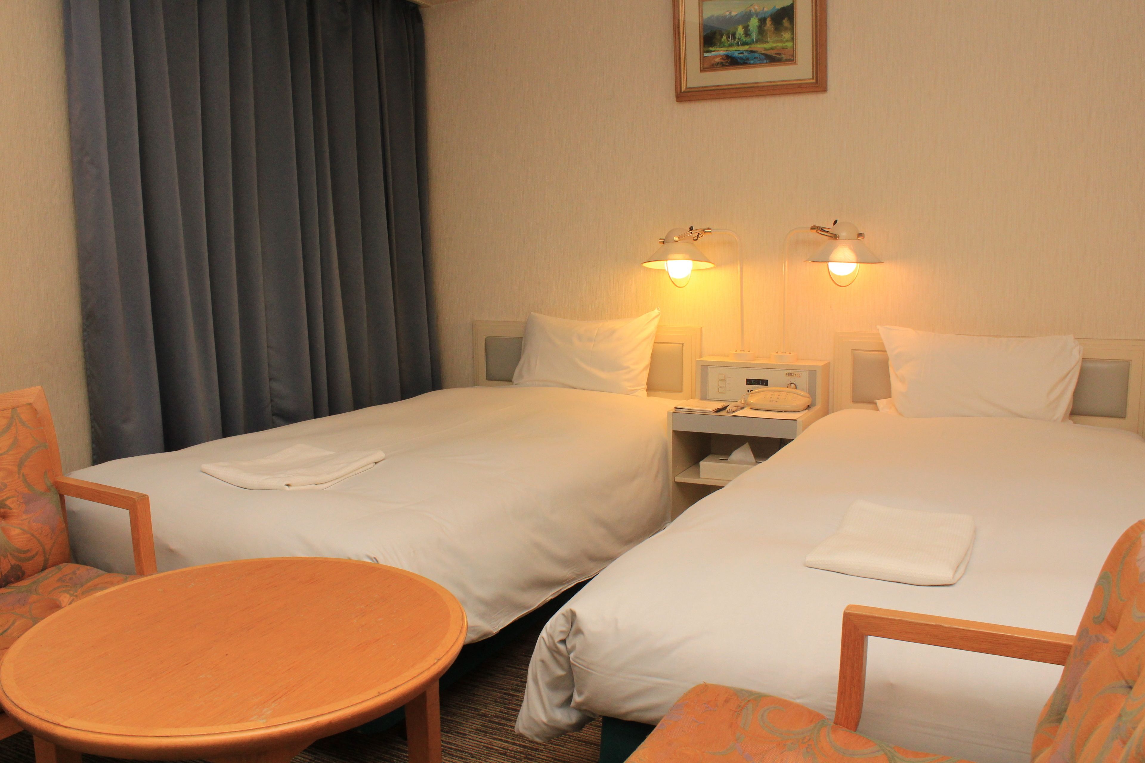 Une chambre d’hôtel avec deux lits, une petite table et une chaise.