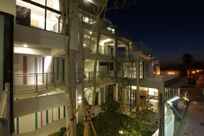 A multi-story hotel with balconies, a central courtyard, and a nighttime view. - Tongzhan Design Inn (Tainan)