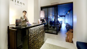 A hotel reception desk with a decorative panel, a clock, and a sign indicating room rates. - Crystal Blue Boutique Hotel (Phnom Penh)