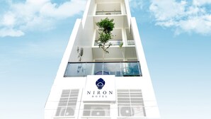 A modern hotel building with a clear sky and a logo at the bottom. - Crystal Blue Boutique Hotel (Phnom Penh)